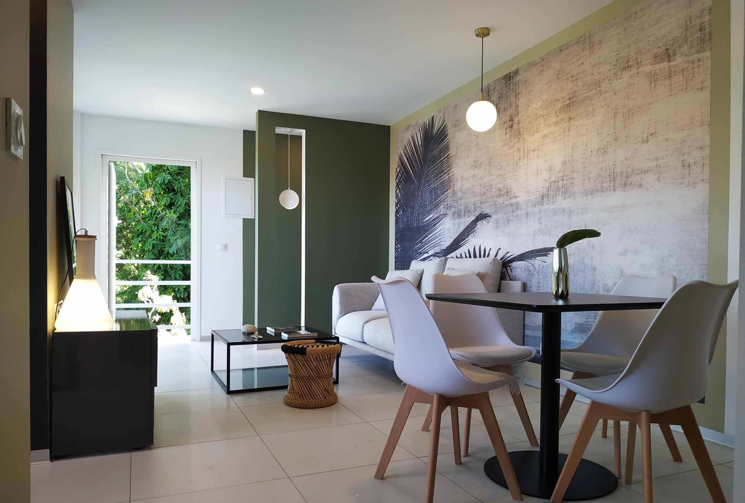 Salon lumineux avec mur végétal imprimé, mobilier contemporain blanc et vert olive, conçu par Grichka Interiors Design