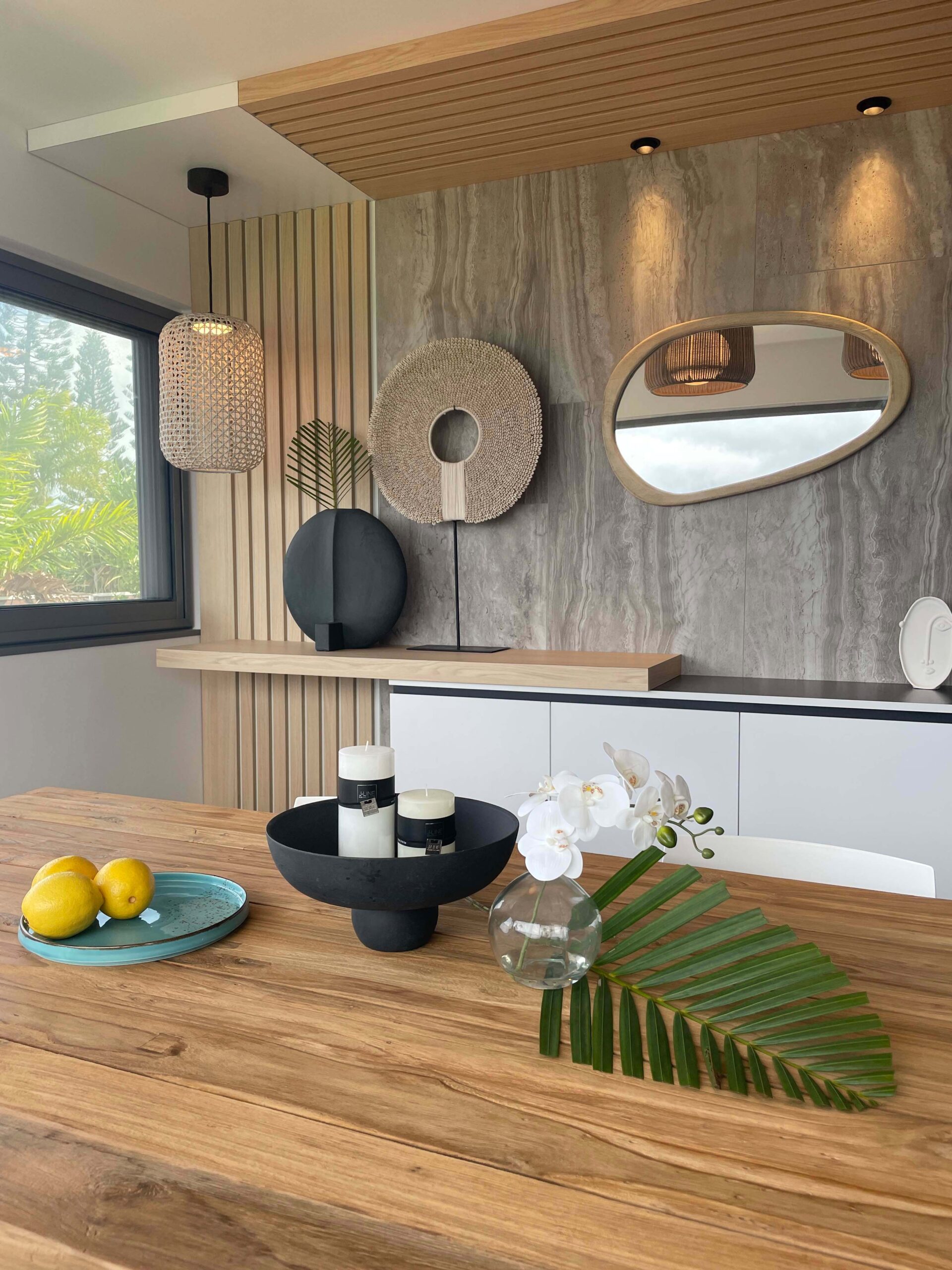 Cuisine design mêlant bois clair, pierre naturelle et éléments décoratifs artisanaux, réalisée par Grichka Interiors Design